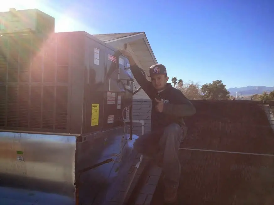 HVAC technician performing Boiler Repair on a rooftop unit in Spirit Lake